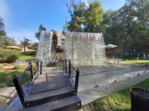 una fuente de agua en un parque con una rampa de madera en Holiday Relax1, en Jagodina