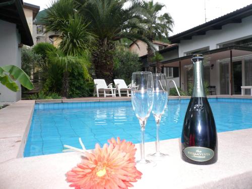 トスコラーノ・マデルノにあるOasi Holiday Homeのプールサイドでのワイン1本とグラス2杯