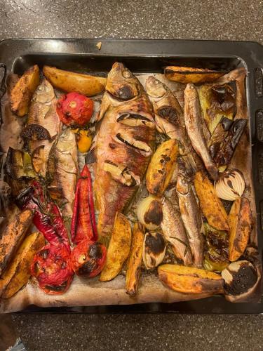 a pan filled with fish and vegetables on a counter at Odo’s Guest House in Martvili