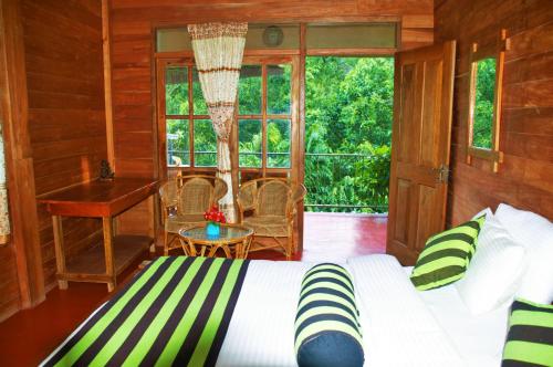 um quarto com uma cama, uma secretária e janelas em Green cottage Ella em Ella