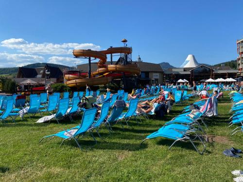 a group of blue lawn chairs sitting in the grass at Apartment Family Besenova - free pool in Bešeňová
