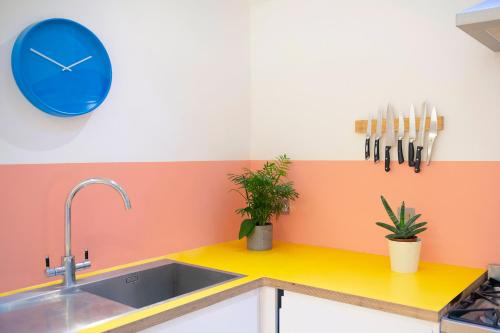 a kitchen with a sink and a blue clock on the wall at Stunning 3-bedroom townhouse in superb location in London