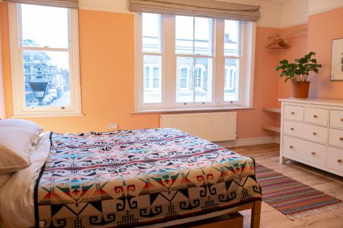 a bedroom with a bed and two windows at Stunning 3-bedroom townhouse in superb location in London