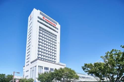 泉大津市にある関空泉大津ワシントンホテルの前に木々がある背の高い白い建物