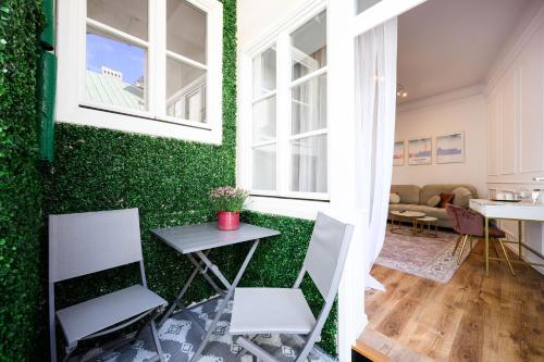 a room with a green wall with a table and chairs at Wiślna Main Square Apartments in Krakow
