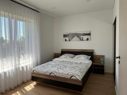 ein Schlafzimmer mit einem Bett und einem großen Fenster in der Unterkunft Villa PANDA HOUSE in Klaipeda in Klaipėda