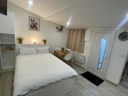 um quarto com uma grande cama branca e uma mesa em Résidence Chene em Viry-Châtillon