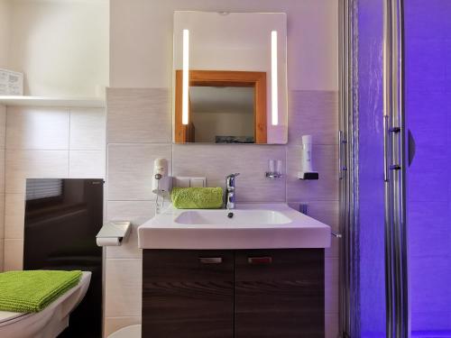 a bathroom with a sink and a mirror at Oberauer Wagrain - Die Eco Familien Hotelpension B&B in Wagrain