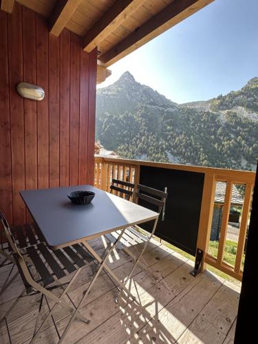 a table and chairs on a deck with a mountain at Arcs 1950 Appartement prestige Ski InOut 6 pax in Bourg-Saint-Maurice