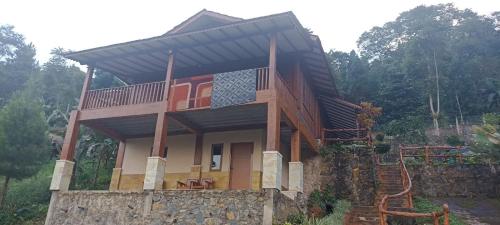 Casa con balcón en la parte superior de una pared de piedra en Villa Hanna 2 en Cisarua