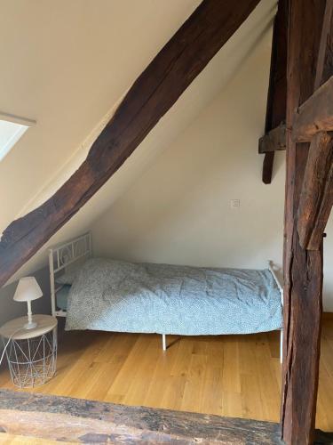 a large bed in the attic of a room at Loft duplex de charme 8 p plein centre in Lisieux