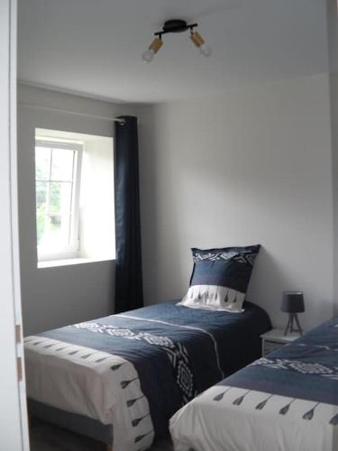 une chambre avec deux lits et une fenêtre dans l'établissement Meublé 2/4 personnes, à Noaillac