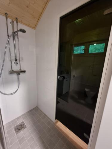 La salle de bains est pourvue d'une douche avec une porte en verre. dans l'établissement Villa Sammalpankko, à Kuopio