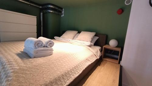 una camera da letto con un letto e asciugamani di DROINVEST Apartament Zarembowicza 33 WROCŁAW LOTNISKO AIRPORT a Breslavia