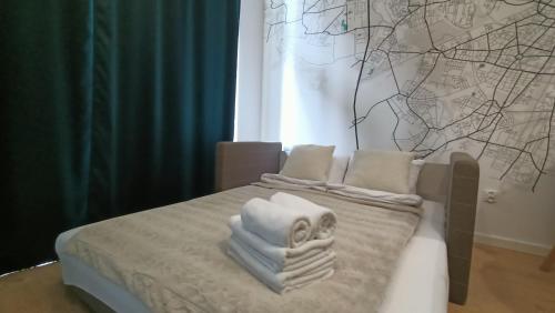 łóżko z białymi ręcznikami na górze w obiekcie DROINVEST Apartament Zarembowicza 33 WROCŁAW LOTNISKO AIRPORT we Wrocławiu