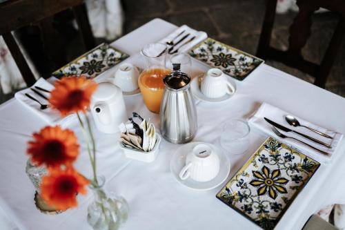 Una mesa con una mesa blanca con flores en un jarrón. en Casa Grande Do Bachao, en Santiago de Compostela
