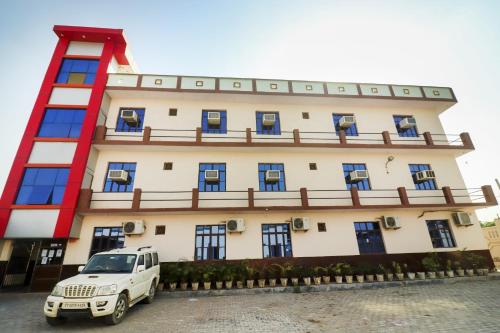 ein weißer LKW, der vor einem Gebäude parkt in der Unterkunft Flagship 72863 New Satkar Hotel in Itimādpur