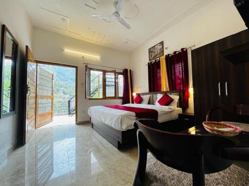 ein Hotelzimmer mit einem Bett, einem Tisch und einem Stuhl in der Unterkunft The Lake House by "Lake & woods" in Bhīm Tāl