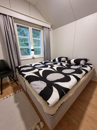 a black and white bed in a room with a window at Villa Sammalpankko in Kuopio