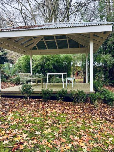 a pavilion with a picnic table and a bench at The Beeches Olinda Accommodation in Olinda