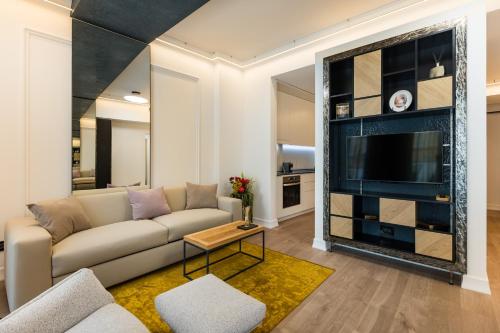a living room with a couch and a tv at Rosetti One in Constanţa