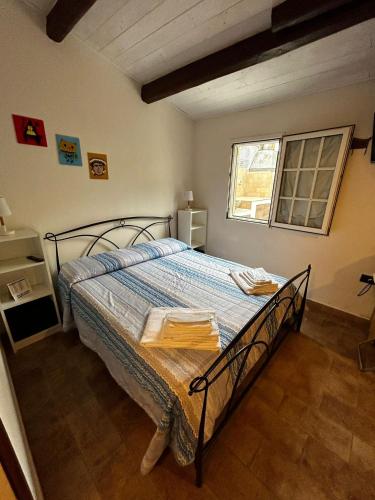 a bedroom with a bed with a blue comforter and a window at Darsena b&b tra arte e mare in Ravenna