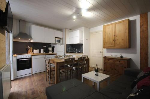 une cuisine et un salon avec un canapé et une table dans l'établissement LE CERF BLANC*** - T4 au pied des Thermes Cauterets - 3 chb et 2 sde, à Cauterets