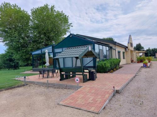 a building with a pavilion with a picnic table at Szárszó Panzió in Balatonszárszó