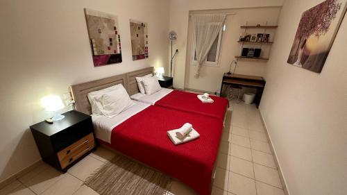 ein Schlafzimmer mit einem Bett mit einer roten Decke in der Unterkunft Patras Palm Tree in Patras