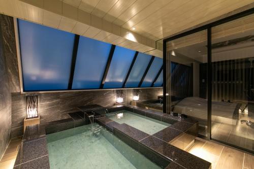 baño con piscina y ventana grande en ホテルカルタ赤坂, en Tokio