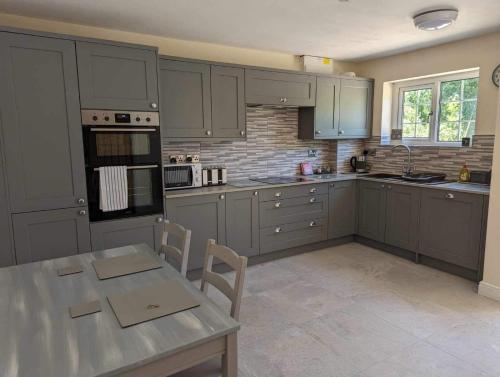 a kitchen with gray cabinets and a table with chairs at The Hideaway in Woodhall Spa