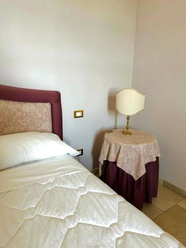 a bedroom with a bed and a lamp on a table at Hotel Saraceno Al Faro in Taranto