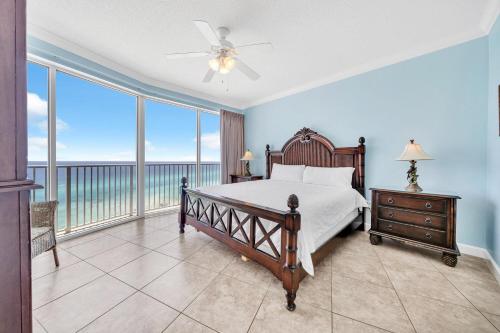 a bedroom with a bed and a view of the ocean at Boardwalk 1209 in Panama City Beach