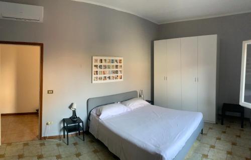 um quarto com uma grande cama branca e uma cadeira em LALE Air conditioning, Wifi, Free parking HOME em Massa