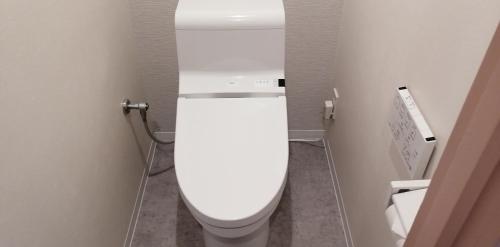 a bathroom with a white toilet in a stall at Hotel Raffinato Chitose in Chitose