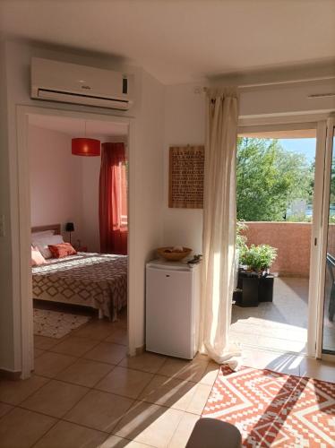 une chambre avec un lit et une porte coulissante en verre dans l'établissement Appartement T2 bord de mer/piscines, à Moriani-Plage