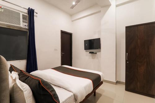 a bedroom with a bed and a flat screen tv at Insight Inn Near Gomti Riverfront Park in Vibhuti Khand