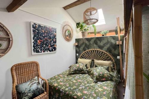 ein Schlafzimmer mit einem Bett und einem Stuhl in der Unterkunft Appartement - Galerie BOTANIC ART Trentemoult in Rezé