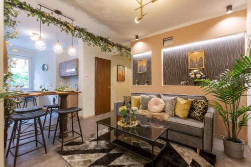 Il comprend un salon et une cuisine avec un canapé et une table. dans l'établissement Stylish Quentin Apartment in the King Street, à Budapest