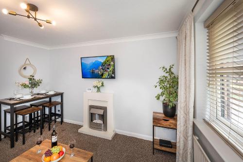 a living room with a table and a fireplace at Train Station Serenity in Staines upon Thames