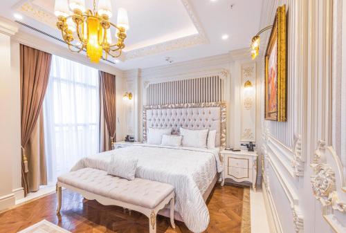 a white bedroom with a large bed and a chandelier at Hilton Garden Inn Samarkand Sogd in Samarkand