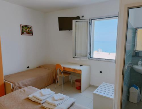 Mały pokój z łóżkiem, biurkiem i oknem w obiekcie B&B Donna Nina w mieście Gioia Tauro