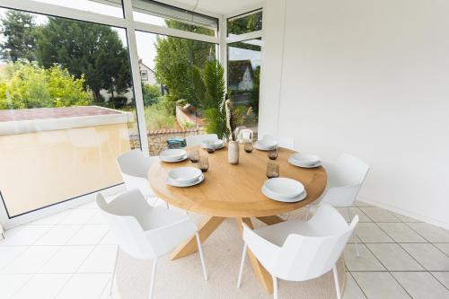 a dining room with a wooden table and white chairs at Appartment in den Weinbergen bei Mainz - mit 2x Doppelzimmern, 1x großes Wohnzimmer, Bad & Küche in Stadecken-Elsheim