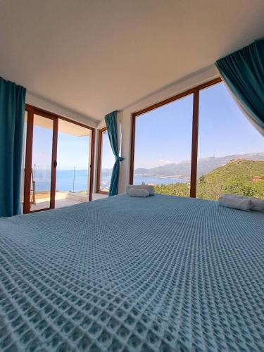 a bedroom with a bed with a view of the ocean at Villa Horus in Sveti Stefan