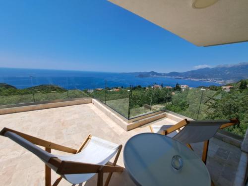 a balcony with two chairs and a view of the ocean at Villa Horus in Sveti Stefan