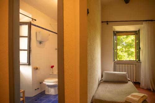 グッビオにあるAgriturismo KeBio I Tenuta di Fassiaのバスルーム(トイレ付)、窓が備わります。