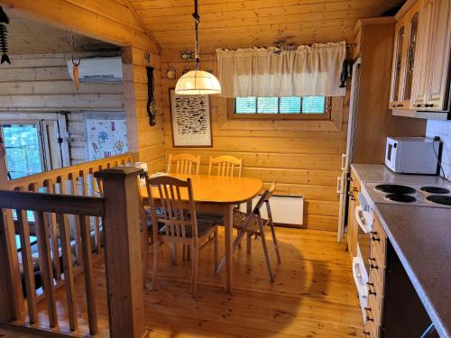 a kitchen and dining room with a table in a cabin at Villa Okra in Rastinniemi