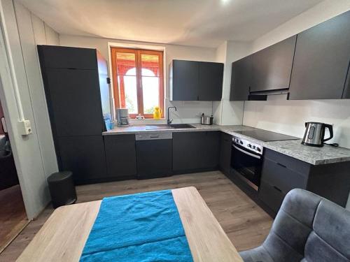 a kitchen with black cabinets and a blue rug at Haus Sonnenblick in Düns