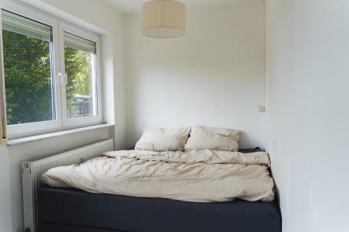 Ce lit se trouve dans un dortoir doté d'une fenêtre. dans l'établissement Appartment in den Weinbergen bei Mainz - mit 2x Doppelzimmern, 1x großes Wohnzimmer, Bad & Küche, à Stadecken-Elsheim