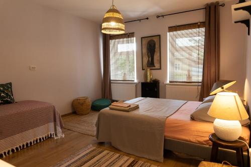 um quarto com uma cama, um candeeiro e 2 janelas em Nomad Sud Studios in Town Center em Cahul